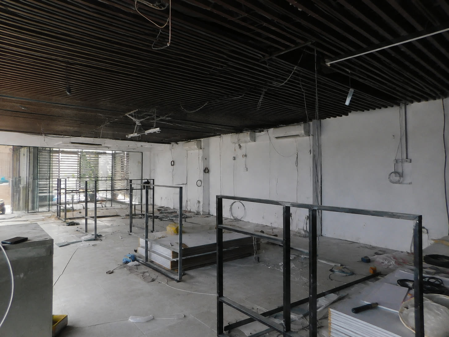 The office floor as a bare shell: stripped walls, exposed services and partition framing going up